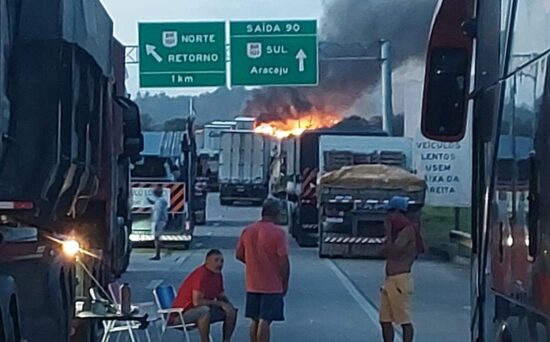Carreta tomba e pega fogo na BR-101 em Capela; tráfego bloqueado