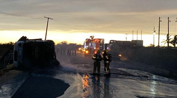 Corpo de Bombeiros combate incêndio em carreta carregada de milho que tombou em rodovia