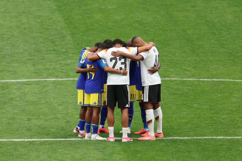 rivais-na-copa-irm-os-na-f-alem-es-e-cura-aoenses-oram-junto-20260615
