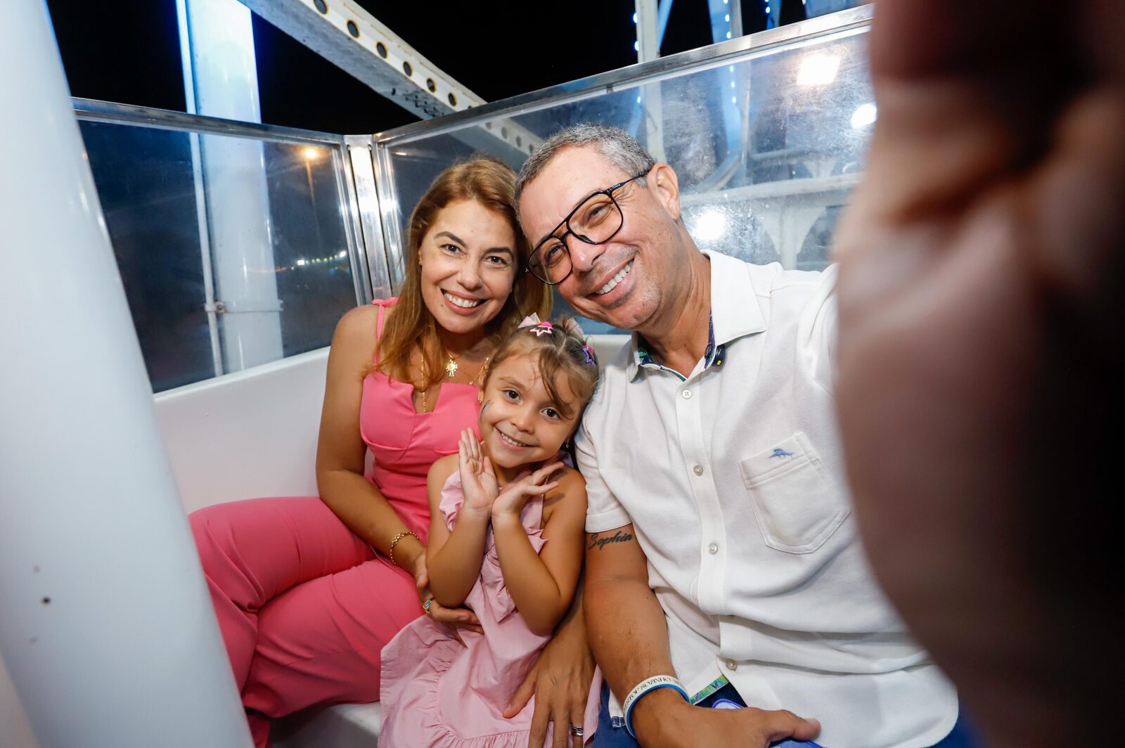 Governador Fábio Mitidieri e a primeira-dama Érica Mitidieri com pequena visitante na roda-gigante da Vila da Criança
